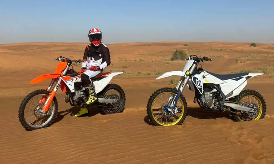 Rider on dirt bike tackling Dubai desert dunes