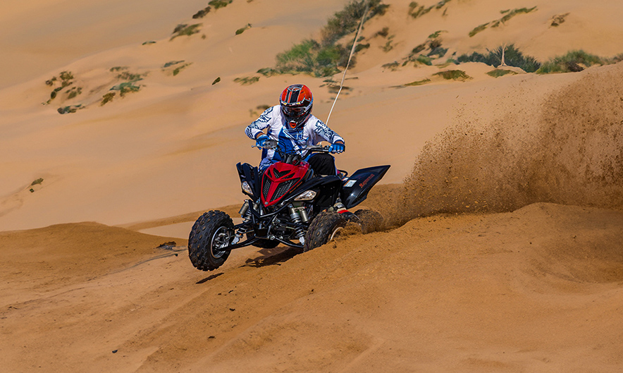 Guest riding quad bike over Dubai desert dunes